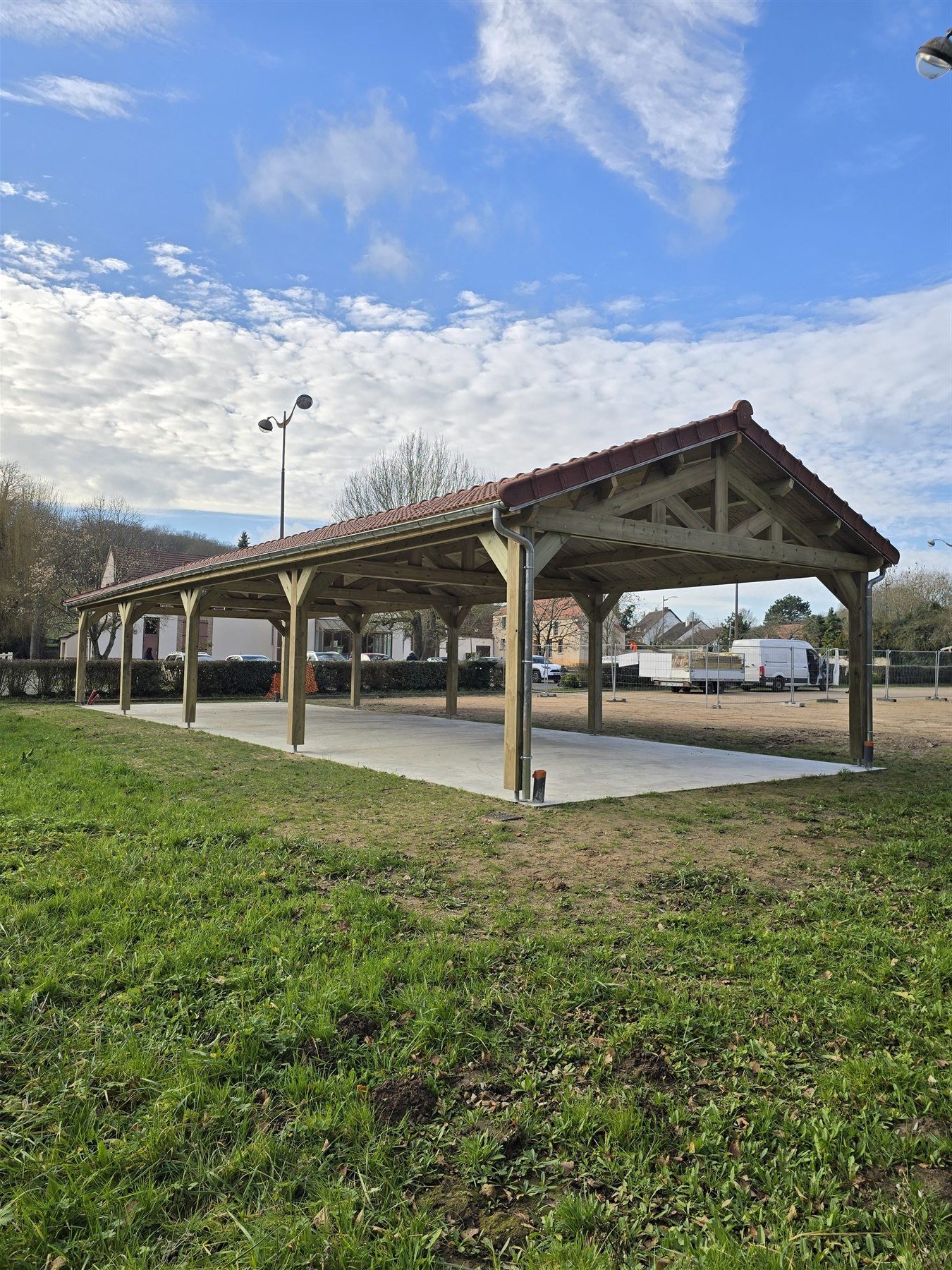 Détail de la charpente apparente et des tuiles du carport à Vert