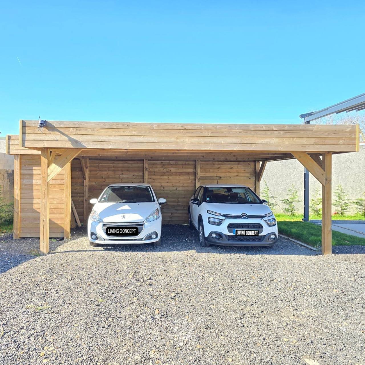 Carport bois semi-fermé sur mesure pour deux voitures exposé au showroom Living Concept de Coignières